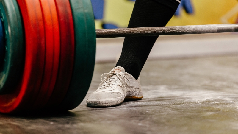 Athlete preparing to lift a loaded barbell during a national-level powerlifting meet