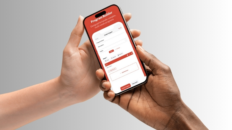 Two hands holding a smartphone showing the Intensity appโs program builder screen for creating a custom training plan