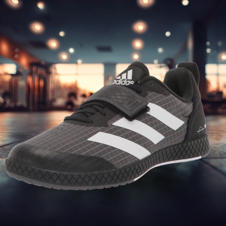 Black Adidas The Total weightlifting shoe with white stripes and flat sole, designed for deadlifts, displayed in a gym environment